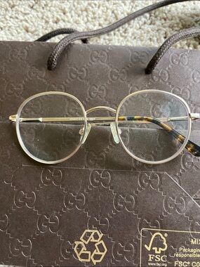 Round Gold Metal Eyeglasses with Tortoise Temples.